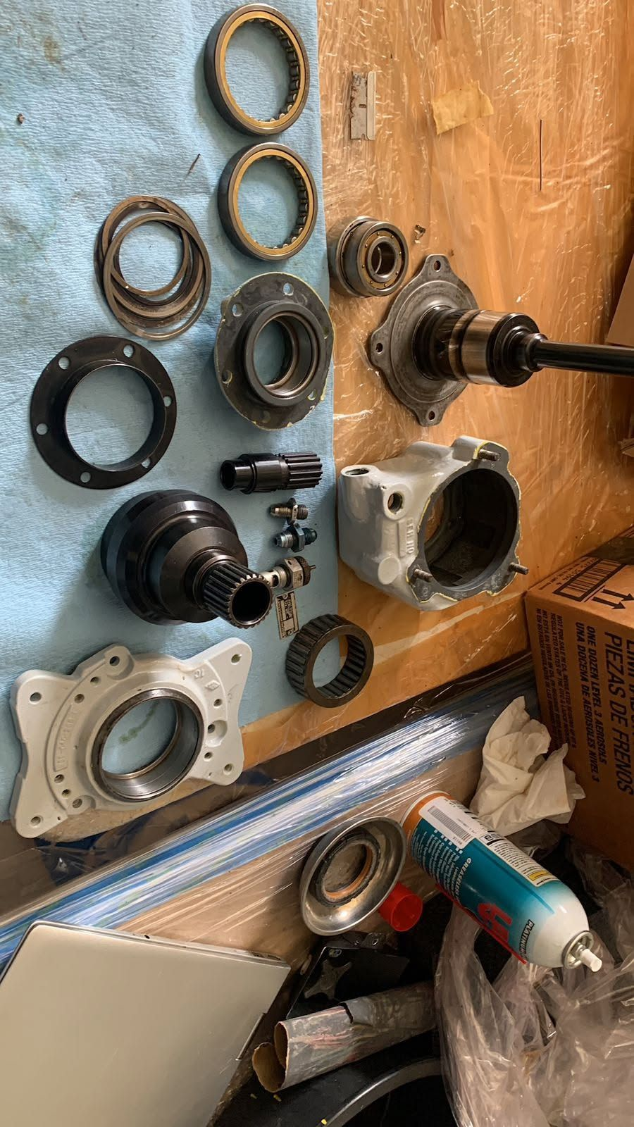 Disassembled helicopter gearbox components, including bearings, housings, seals and splined shafts, laid out for inspection and overhaul.