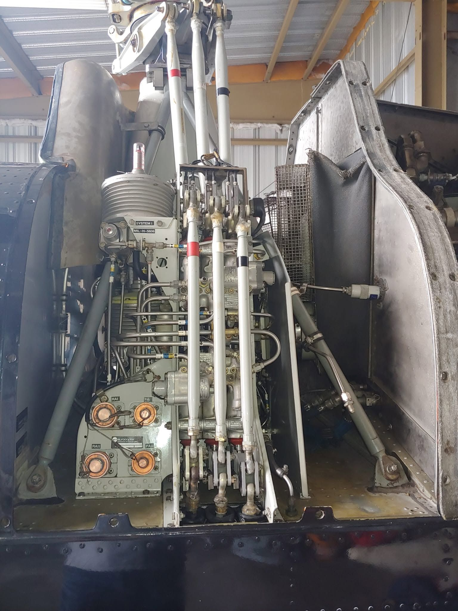 Eurocopter hydraulic system and flight control servos installed on the helicopter's upper deck, with cowlings open for inspection.